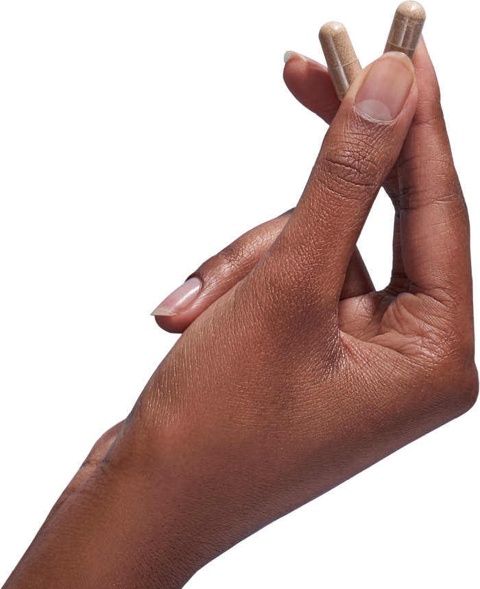 image of hand holding 2 Performance Lab® AU Vitamin C capsules